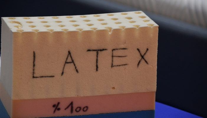 Closeup of a chunk of latex mattress labeled as 100%