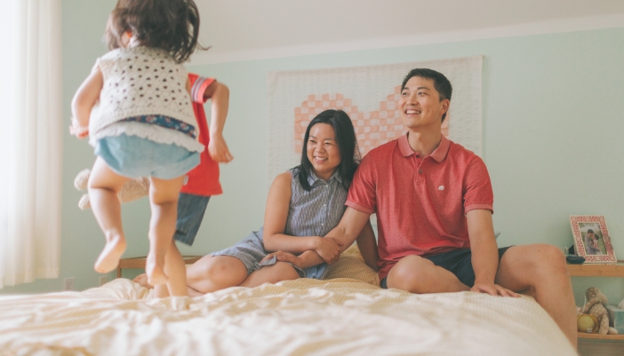 Two kids jumping on their parents bed