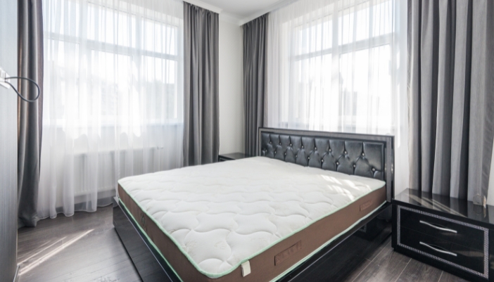A beautiful bedroom with a button-tufted bed frame