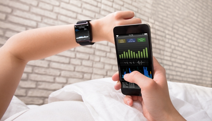 Woman checking her sleep patterns on her phone from her sleep tracker