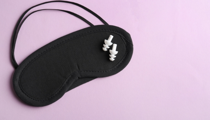 A closeup of a sleep mask and sleep ear plugs