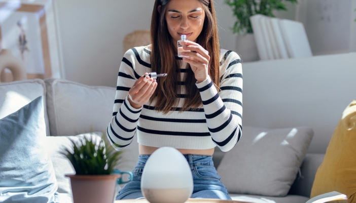 A woman smells her essential oils before putting it into her diffuser.