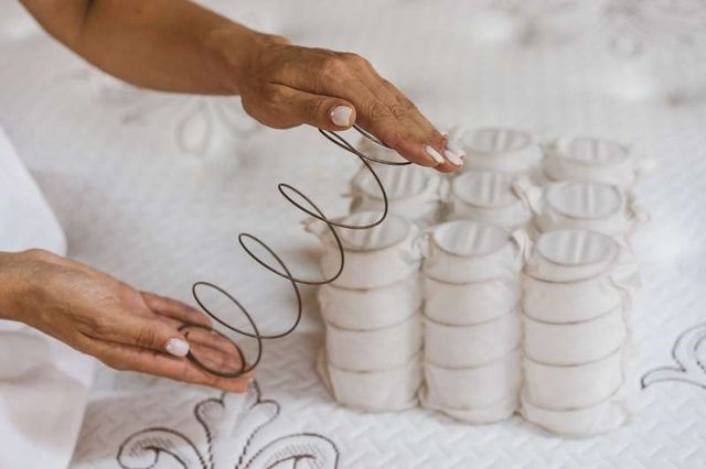 close view of two hands holding mattress coils