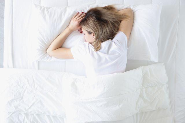 View of a woman sleeping on her stomach