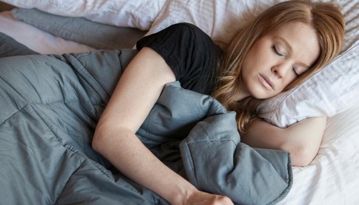 Woman sleeping with a weighted blanket