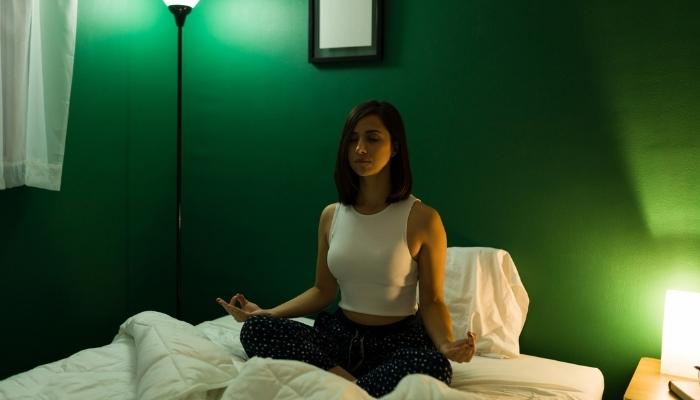 Woman meditating in bed