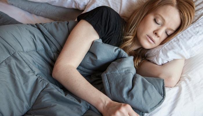Woman peacefully sleeping with weighted blanket