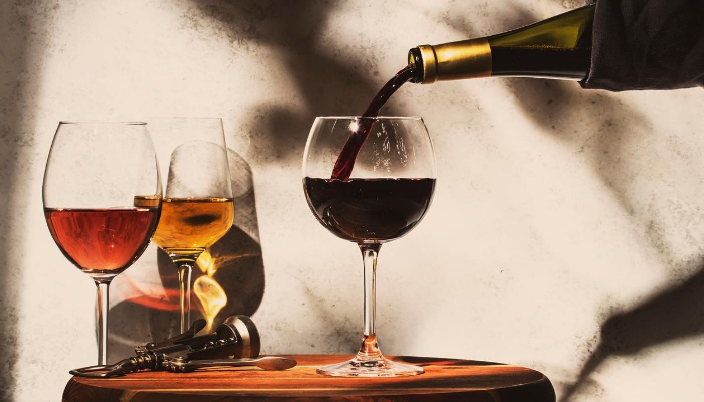 pouring a glass of wine on a nightstanf