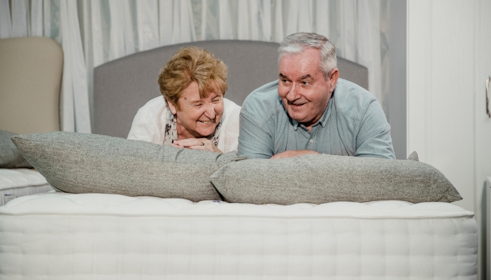 A senior couple testing out a mattress in store