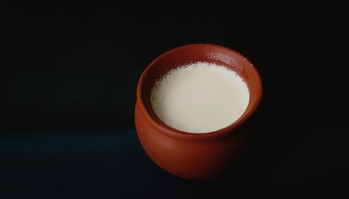 Closeup of warm milk in an clay pottery cup