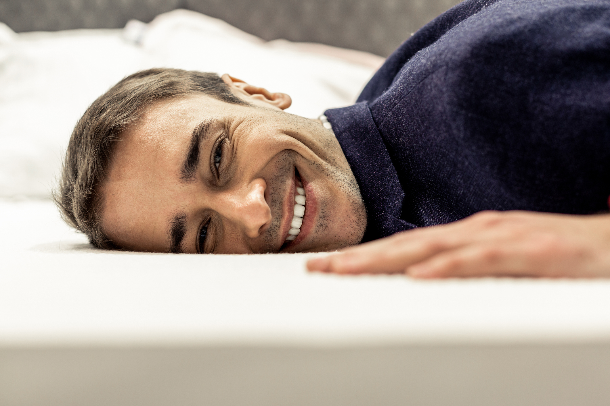 smiling man lying on memory foam mattress