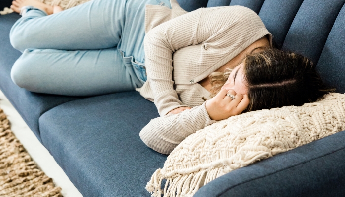 woman taking a nap on a blue couch 