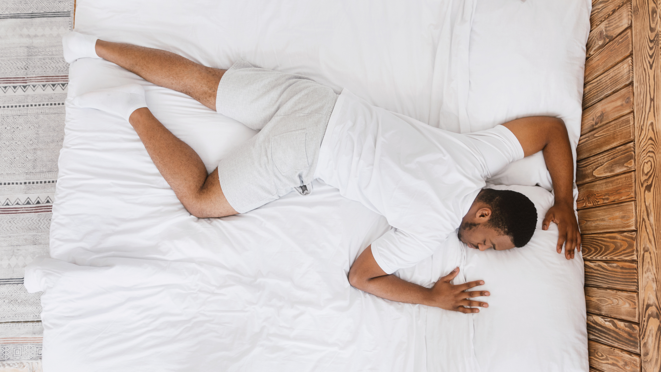 African American man sleeping on stomach in bed