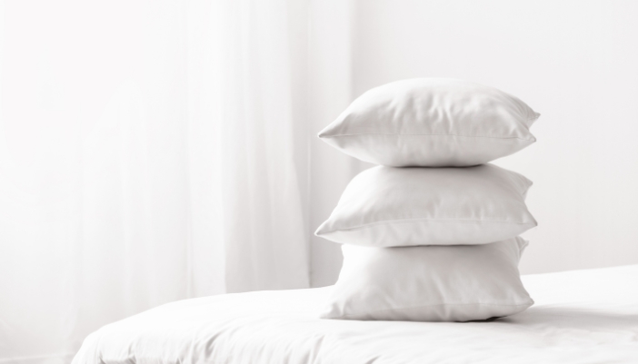 A stack of pillows on top of a bed