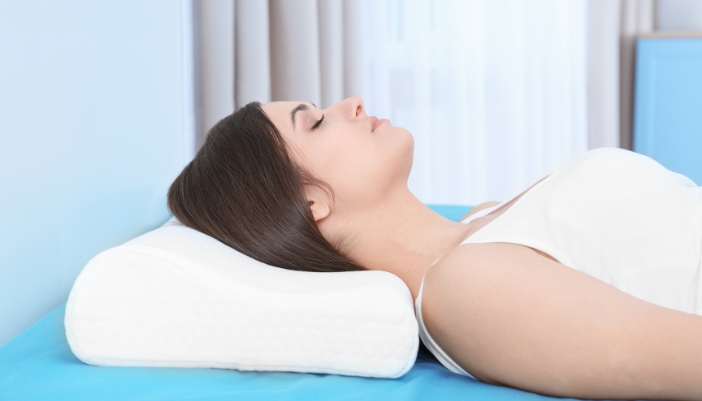 Woman sleeping on curvature pillow for her neck and spine