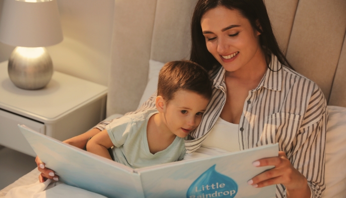 Young mom reading to her son before bed