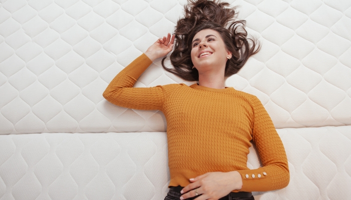 Woman trying out the feel of a mattress