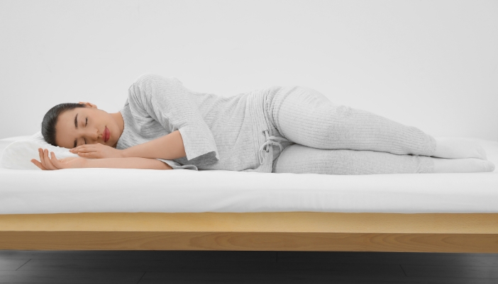 Woman sleeping on a mattress and pillow with perfect spinal alignment