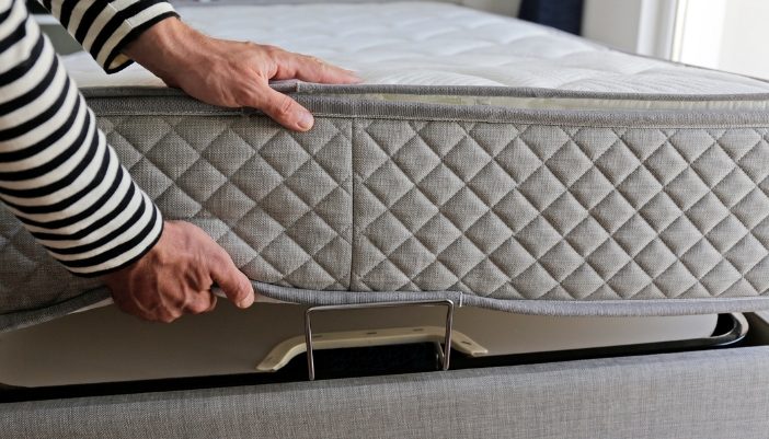 Closeup of someone placing their mattress on top of an adjustable foundation