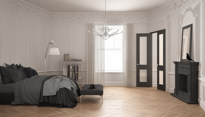 Bed with dark linens facing the door in the "death" position