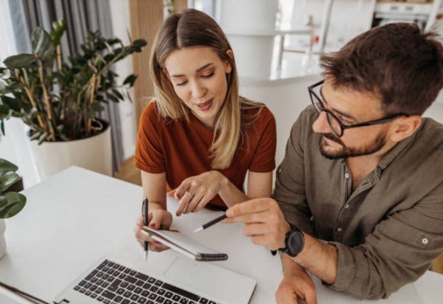 front view of a man and woman reviewing finances in front of a laptop