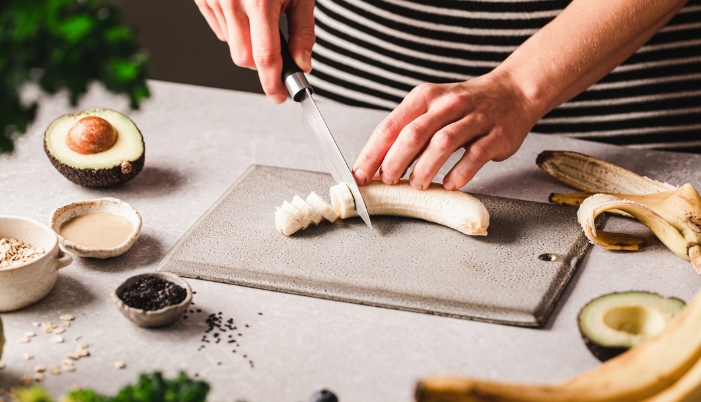 Closeup of someone slicing a banana for their snack