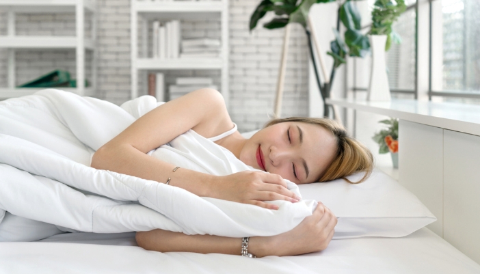 Asian woman sleeping peacefully on her mattress while on her side