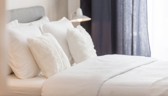 white plush bed with fluffy pillows 