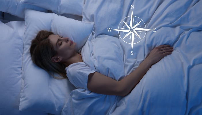 A woman sleeps with her head facing east. A compass is also present.