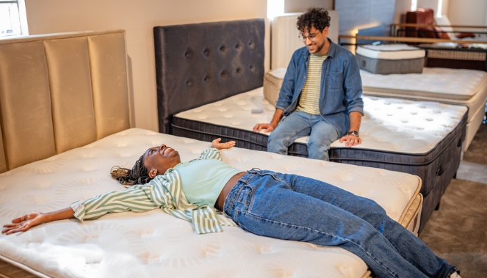 A couple shops together for a new mattress in showroom.