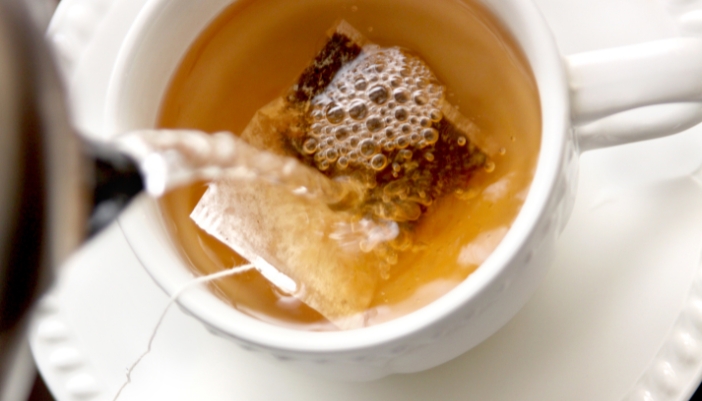 A closeup of a tea bag steeping in a teacup. 