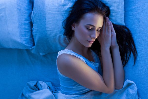 Overhead view of a woman sleeping under a blue lens 
