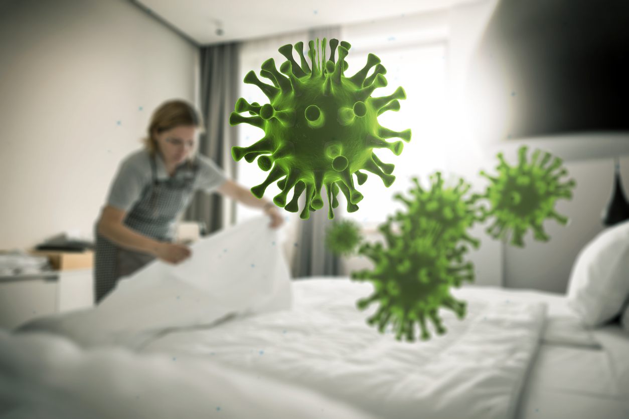 Graphic of bacteria floating in air while woman in background makes a bed 
