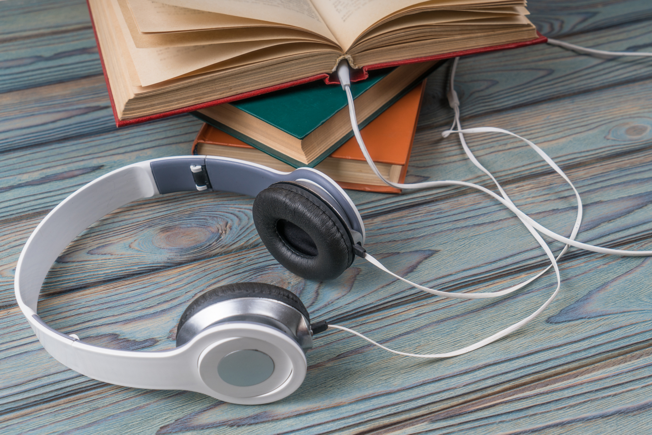 stack of books with headphones