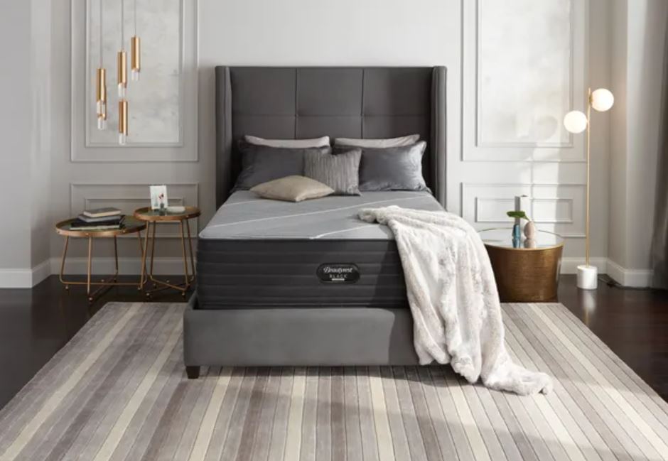 A Beautyrest Black mattress is shown in an elegant bedroom with gold fixtures and accent furniture