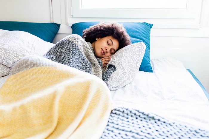 Young woman sleeping in a bed.