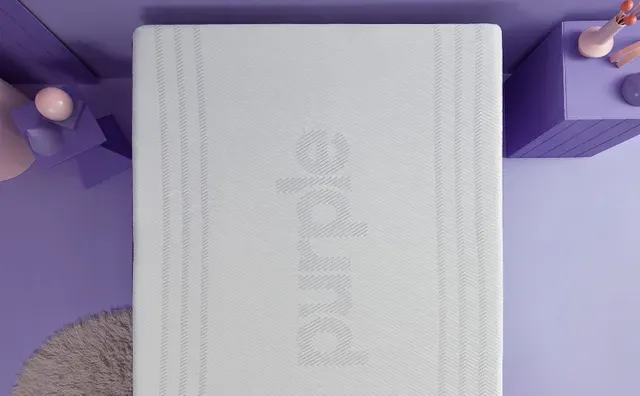 top view of a purple mattress in an all purple stylized bedroom