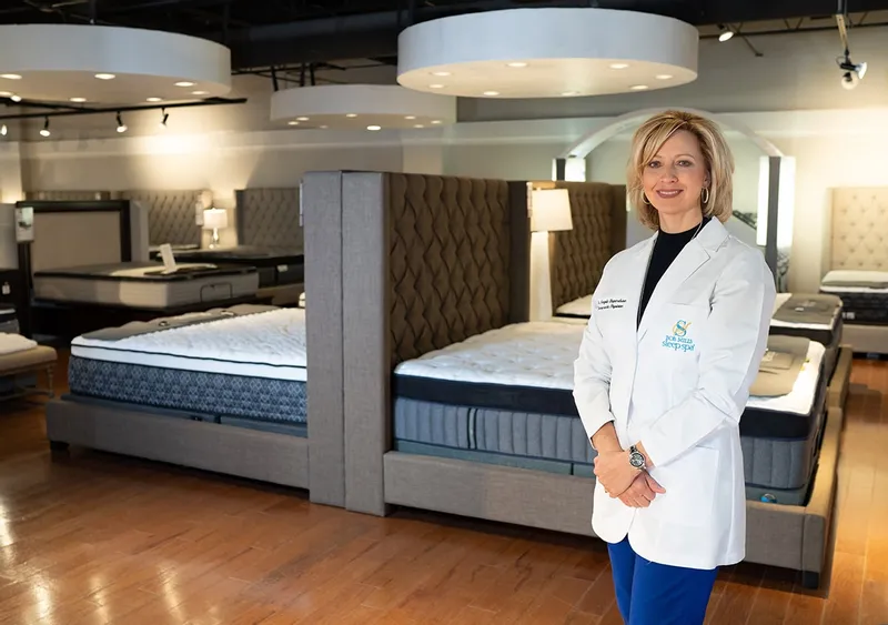 Dr. Angie Shepardson posing in from of the bedroom stock at Bob Mills Furniture 