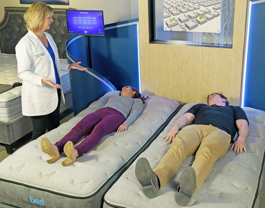 Dr. Angie Shepardson running sleep measurements for a man and a woman 