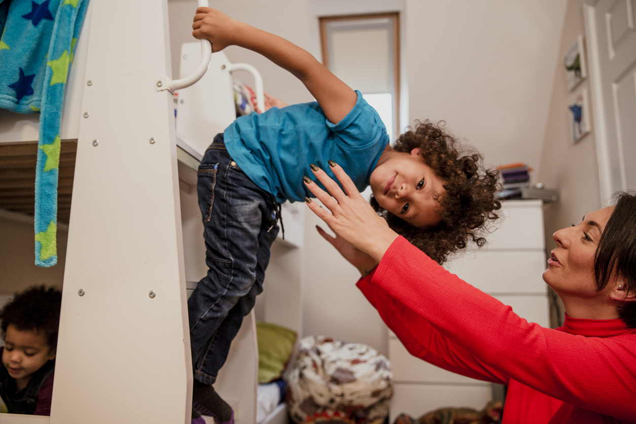 mother tries to pick up young son from bunk bed ladder