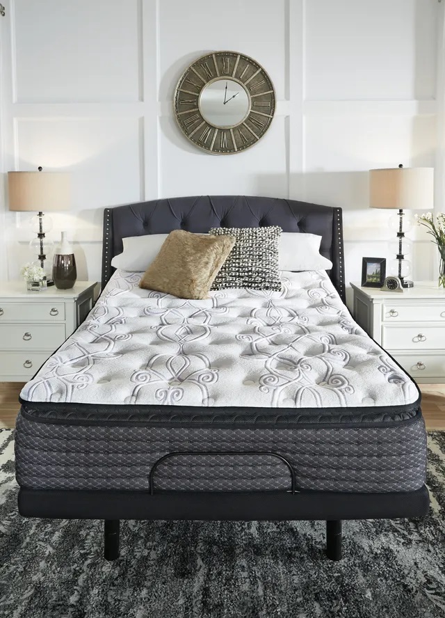 Stock photo of a full size pillow top mattress in a modern bedroom with pillows sitting near the headrest. 