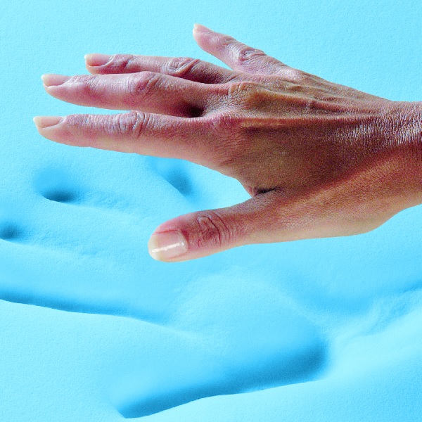 A person pressing down on memory foam found inside a Restonic mattress 
