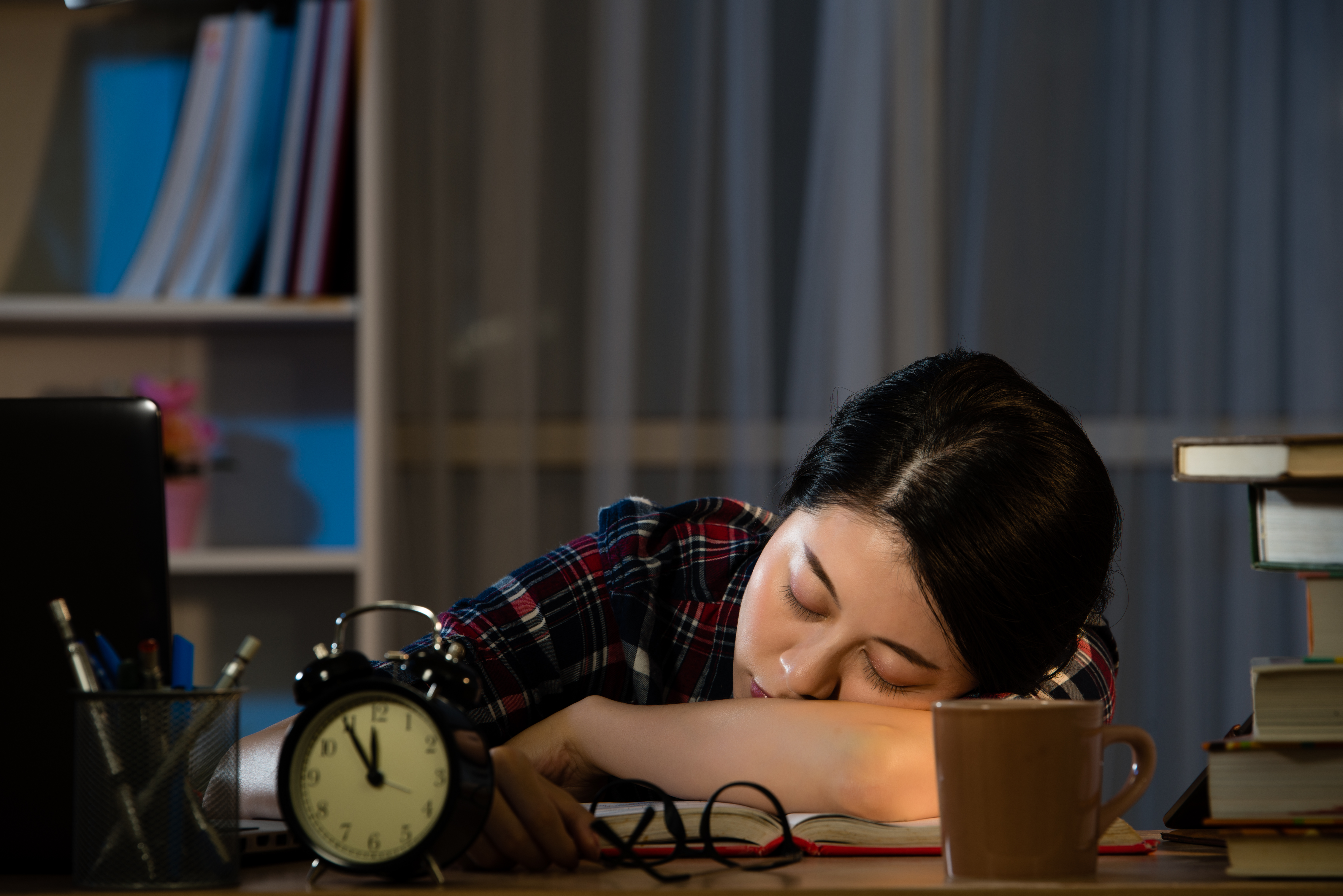 A college student sleeping at a desk 