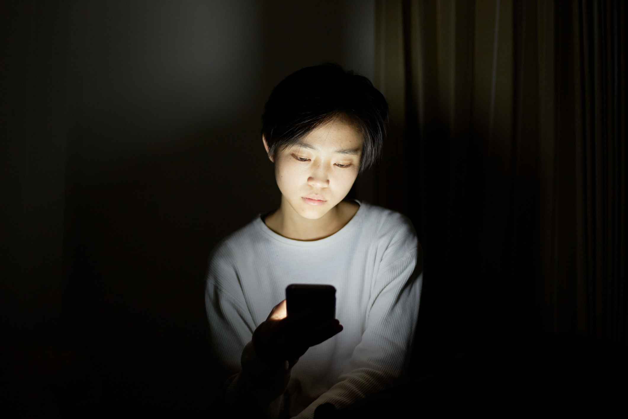 young woman using smart device in dark