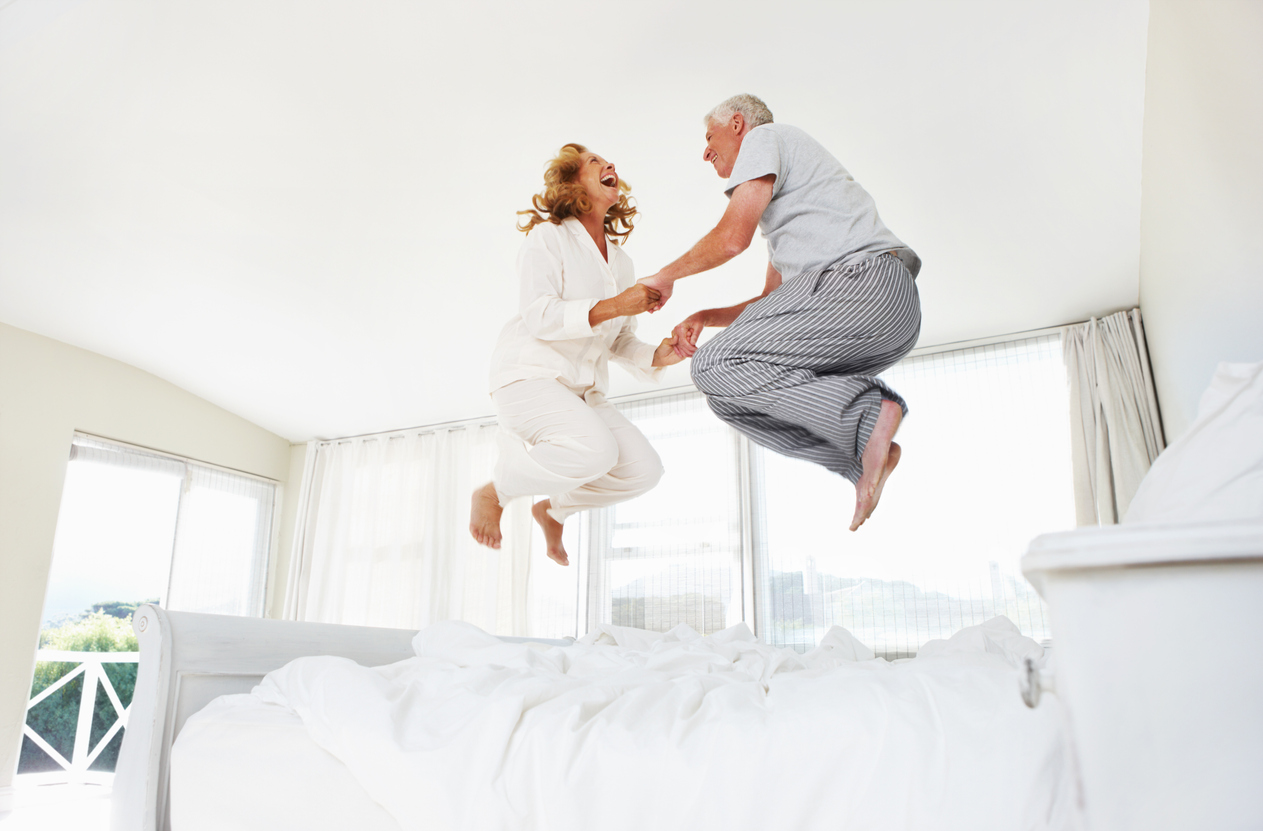 a mature couple jumps on their new mattress 
