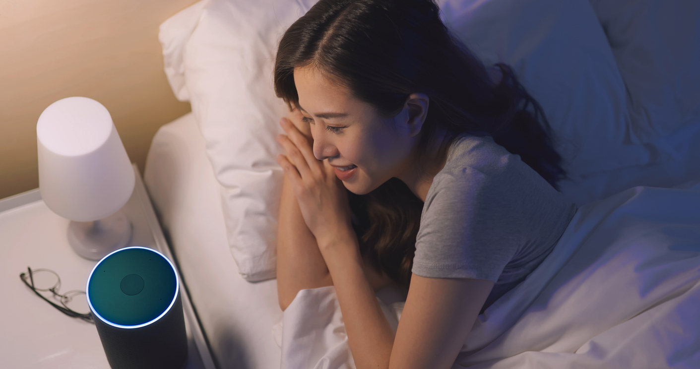 woman uses voice control to turn off the light