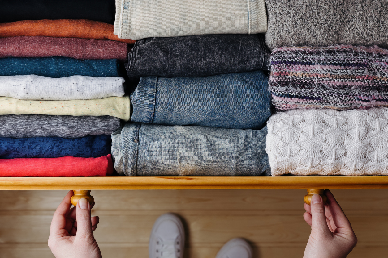 overhead shot of neatly ordered clothes in wooden drawer