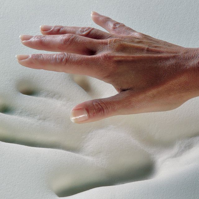 hand pressing onto memory foam mattress