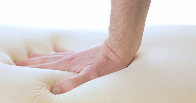closeup view of a hand pressing down onto a memory foam mattress