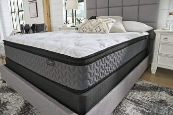The Sierra Sleep by Ashley 12” hybrid Euro top mattress in a bedroom with bedding and décor 
